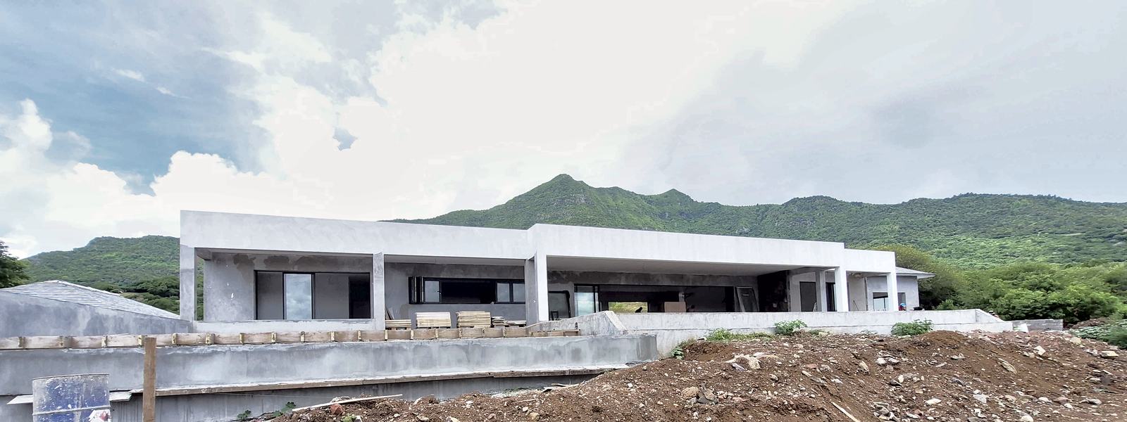 Grande villa de plain-pied en chantier, au pied des montagnes