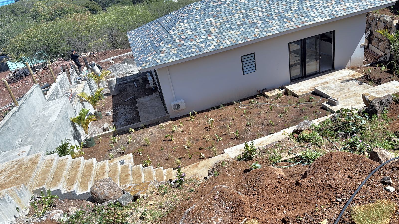 Maison sur terrain en pente avec escalier et jardin en cours d'aménagement