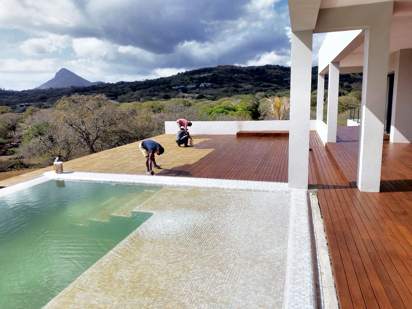 Terrasse en bois autour d'une piscine à débordement, villa de prestige avec vue montagne